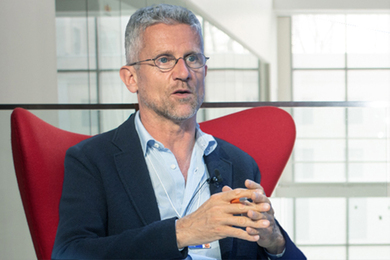 Photo of Carlo Ratti seated and conversing with someone off-camera