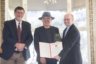 Robert Shin, posing with an award plaque, stands between Robert Gierard and Mark Couch