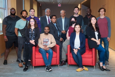 Photo of 12 fellows, standing and seated, flanking Anantha Chandrakasan and Daniel Hastings