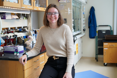 Portrait photo of Alexis Hocken sitting at a lab bench
