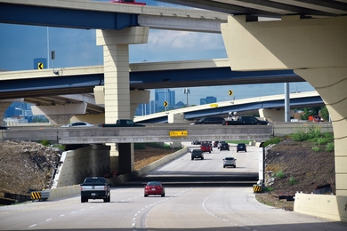 Photo of an interstate exchange paved with concrete. There are at least five bridges or flyovers over the main road.