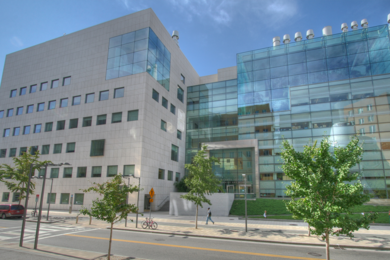 Street view of MIT Building 46, a large research building with a concrete-and-glass facade