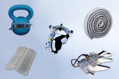 Five objects appear on a whitish background: A blue kettlebell with some microchip components, a silver ringlike object with wires, a roll of corrugated white plastic, a white glove with wires on it, and an off-white corrugated piece of plastic. 
