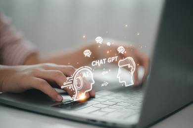 Hands are typing on a laptop, and glowing speech bubble icons emerge that say, “AI, Chat GPT.”
