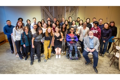 More than 30 people pose for a group photo in front of a sliding screen cover at Catalyst restaurant