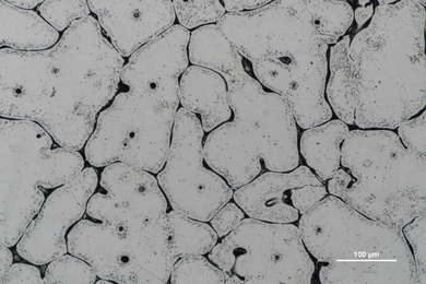 A microscopic view of metal surface captured with a scanning electron microscope, revealing intricate microstructures and grain boundaries