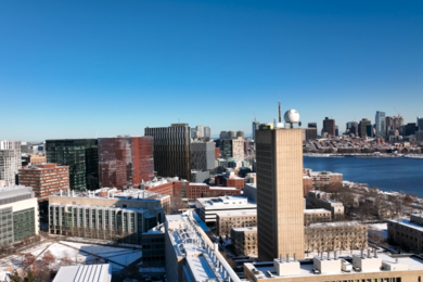 A drone's view of a snowy MIT campus with Boston skyline in background