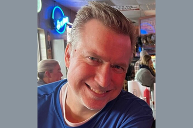 Photo of Casey Harrington smiling while at a restaurant.