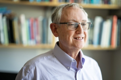 Photo of Rob Townsend posing in front of a bookshelf