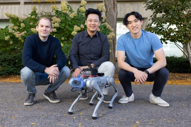 Alan Yu, Phillip Isola, and Ge Yang squat behind a small silver quadruped robot