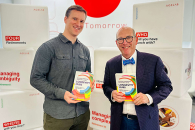 Luke Yoquinto and Joe Coughlin pose with copies of "Longevity Hubs: Regional Innovation for Global Aging"