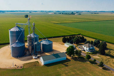 Aerial view of a farm with large silos.