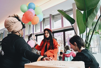 Two women talking, one holding a bunch of colorful balloons