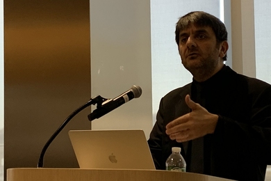 C. Cem Tasan standing at a lectern 