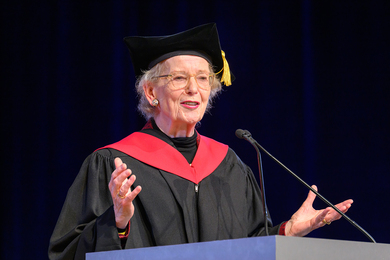 Mary Robinson, in academic black robe and hat, speaks at a podium