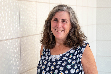 Mary Gallagher poses in front of white tiles