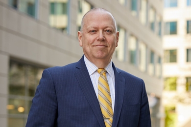 Michael Moody stands outside an office building on a sunny day