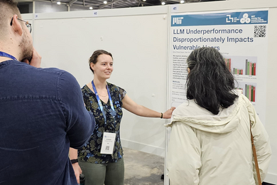 Elinor Poole-Dayan presents a paper poster to two people