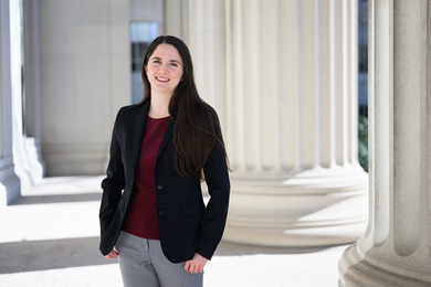 Lauren Fortier poses outdoors amidst large architectural columns