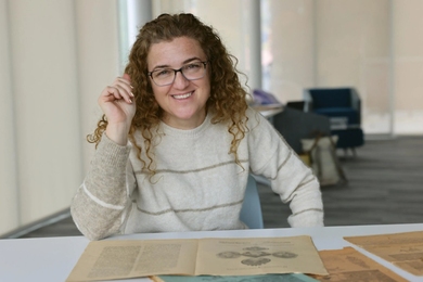 Lerna Ekmekcioglu, seated at a table with old documents on it