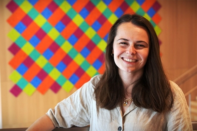 Bailey Flanigan headshot in front of brightly colored checkerboard pattern art