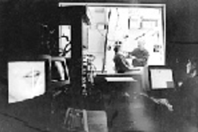 Senior research scientist Joseph S. Perkell (center) attaches electrodes to electrical engineering and computer science graduate student Adrienne Prahler to gather data about speech motor control. Engineer Majid Zandipour (right foreground) operates the computer in an adjoining room.