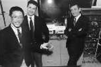 Professors Yet-Ming Chiang (left), Gerbrand Ceder (center) and Donald Sadoway have developed a new material for rechargeable batteries, which Dr. Chiang holds in his left hand. Behind them is the apparatus used to test the new batteries against old ones.