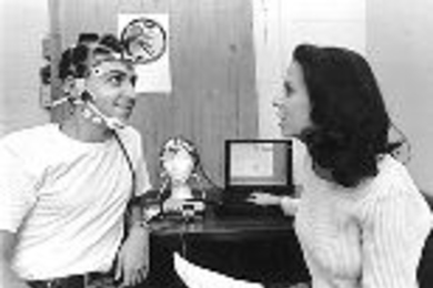 Luca Callini (left), who just received his master's degree in aeronautics and astronautics, looks up at a command from graduate student Suzanne Essig as they work with a piece of headgear that's part of an experiment that will go up on the shuttle with astronaut John Glenn this week. The laptop in the center displays and analyzes physiological signals coming from the headgear.
