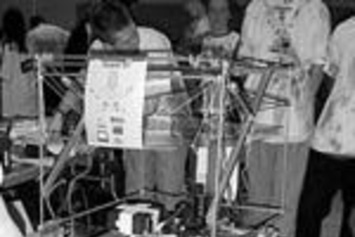 MIT team member Erix Wilhelm tightens the chain on the MIT/CRLS Psychedelic Team robot entry in the FIRST competition.