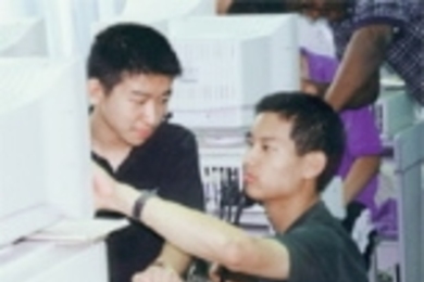 On his trip to China, MIT student Roger Hu (right) gives some computer instruction to a student from a high school attached to Tsunghua University.