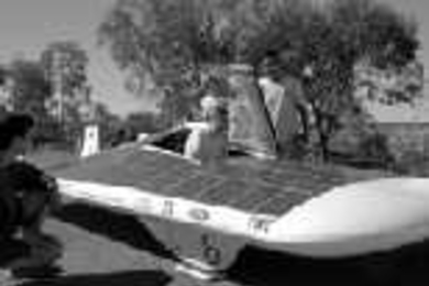 Student SEVT members Brian Graham (crouching), Nathan Ickes (standing, left) and Iahn Cajigas (standing, right) help driver Jacinda Clemenzi into the Manta GTX before starting a leg of the Australian World Solar Challenge.