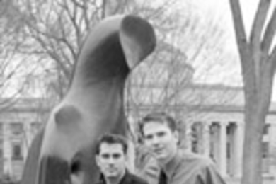 Jamie Heywood (right) quit his job in California to start a foundation to find a cure for ALS, a disease which is weakening his brother Stephen (left). Behind them is A Reclining Figure, a Killian Court sculpture that was a favorite of Jamie's during his student days at MIT. Their father is Professor John Heywood of mechanical engineering.