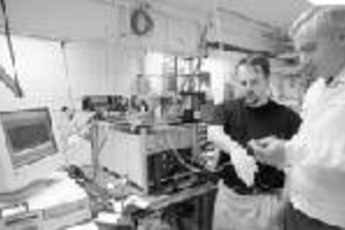 Professor Michael Feld, director of the Spectroscopy Lab (right), tests a device which uses light to identify cancer cells in a noninvasive test on postdoctoral associate Adam Wax.
