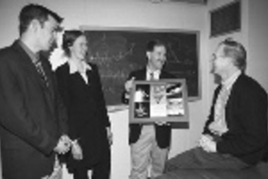 Astronaut and MIT alumnus John Grunsfeld, holding a framed collection of MIT flags he took into space with him, talks about his flights with UROP assistant director Michael Bergren (left), UROP program assistant Melissa Martin, and Professor Kim Vandiver (far right), director of the Edgerton Center and dean for undergraduate research.