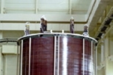 The inner module of a superconducting magnet built by the US team (left photo), with magnet team members including Rui Vieira of MIT (far left); and the outer module built by the Japanese team (right photo).