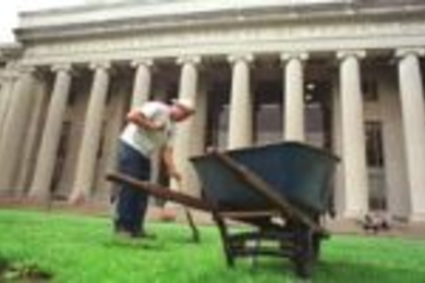 John Devlin of Faciltiies' grounds crew uncovers the built-in supports for the stage that's about to be installed for Commencement.