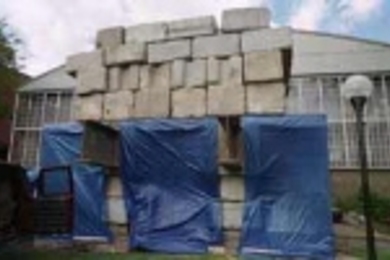 Two hundred tons of steel and cement, twice the weight to be carried by the columns of the Sports and Fitness Center, were used in this load test of the first footing for the new center, which will be on the filled land of the MIT campus. Engineers found sand 20 feet down and hollowed out a bulb for the pressure-injected footing for the column of cement to stand on.