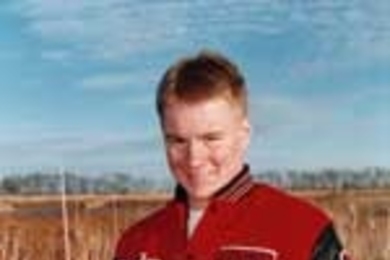Jordan Sand, winner of the Lemelson high school apprenticeship award, stands among cattails, holding an alternative form of paper he made from corn, flax, wheat and cattails.