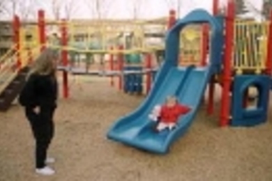 Loni Butera watches her daughter Lara enjoying the slide in the new playground at Westgate.