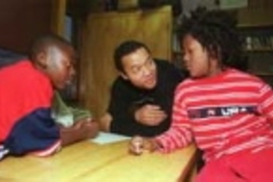 George Samuels (center) helps 11-year-olds Corey Godfrey (left) and Francis Reddick plan how to finance a holiday event they want to hold at the Area IV Youth Center. Mr. Samuels is one of several DUSP graduate students involved in the Young People in Planning project at the center.