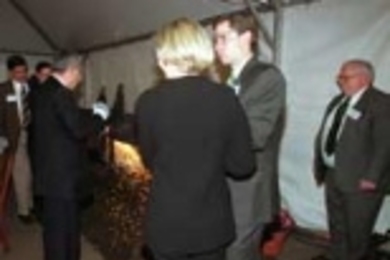 Richard P. Simmons, retired head of metals manufacturer Allegheny Technologies, familiarly wields a plasma arc cutter to slice through the loops of a two-foot bow and stainless steel ribbon at the "ribbon-cutting" for Simmons Hall. Holding the ribbon at each end are (left) his daughter Amy and her husband Sean Sebastian, and (right) his son Brian and his wife, Julie Simmons.