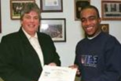 Campus Police Chief Anne P. Glavin presents senior Ricardo Dawkins with a citation recognizing his bravery in assisting state and campus police in pulling a woman out of a burning car on Memorial Drive.