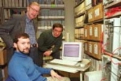 Research scientist Chris E. Forest (seated), Professor Peter H. Stone and research scientist Andrei P. Sokolov (right) gather around a monitor displaying their climate model, which reduces the uncertainty of global climate change predictions. On the screen is a temperature record for the global mean surface temperature from 1900 to 1998.