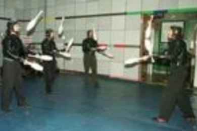 The Flying Karamazov Brothers, demonstrating their juggling and comedy act in the Media Lab atrium, collaborated with Professor Neil Gershenfeld (seated at computer bank at back) and colleagues at the Media Lab to incorporate technology such as sonar tracking of the performers, programmable club displays and interactive computer vision and graphics.
