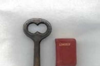 The key measures 2 9/16 inches high. The book is 13/16 by 9/16 inches.