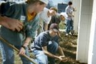 HST students and others get elbow-deep in yard work on the first Community Service Day at McInnis House in Jamaica Plain.