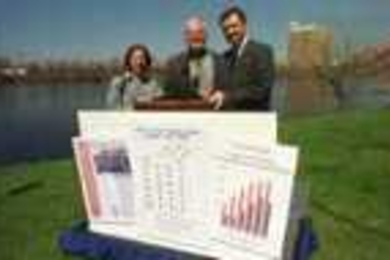 The EPA issued its annual report card on the quality of the Charles River last Friday at Magazine Beach in Cambridge. Left to right: MIT's Jamie Keith and Paul Parravano, and the EPA's Ira Leighton show the river's grade -- a B.
