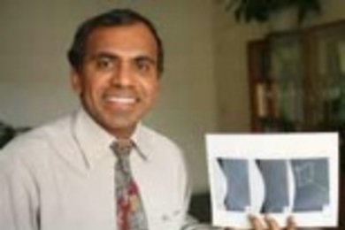 Professor Subra Suresh holds images of the bubble experiment that has informed his study of the movement of atoms.