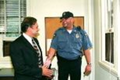 Patrolman Joe West (right) greets new MIT Chief of Police John DiFava, noting that he just had the chief's office window to his left repaired.