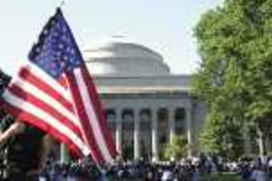 A student displays the American flag at a gathering of thousands of MIT community members on Killian Court last Wednesday.